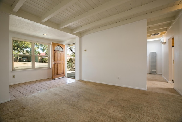 carpeted foyer featuring beamed ceiling