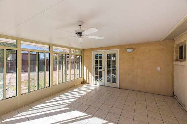 unfurnished sunroom featuring ceiling fan and french doors