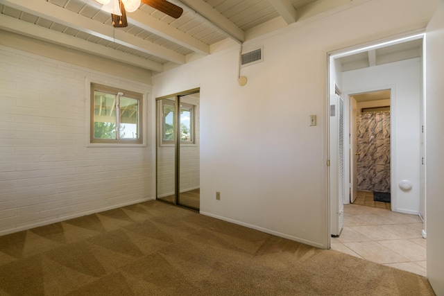 unfurnished bedroom with brick wall, ceiling fan, wood ceiling, light carpet, and beam ceiling