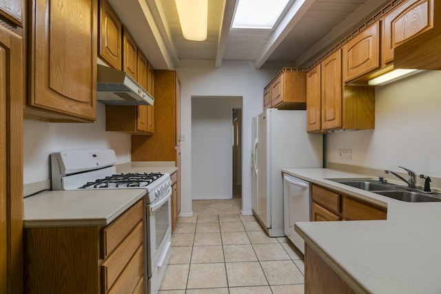 kitchen with sink, white appliances, beamed ceiling, and light tile patterned flooring