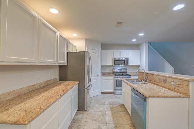 kitchen featuring sink, light stone countertops, white cabinets, and appliances with stainless steel finishes