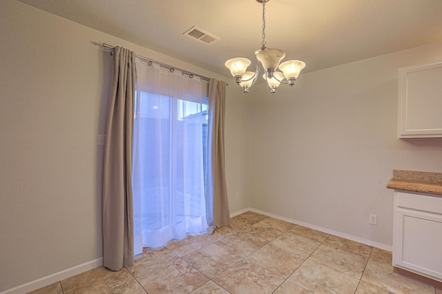 unfurnished dining area with a chandelier and light tile patterned flooring