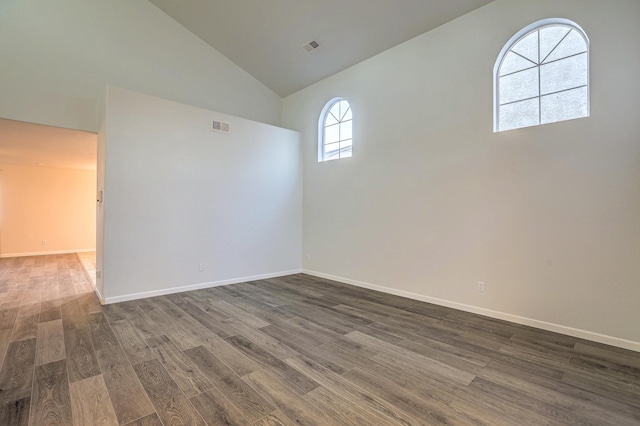 spare room with high vaulted ceiling and dark hardwood / wood-style flooring