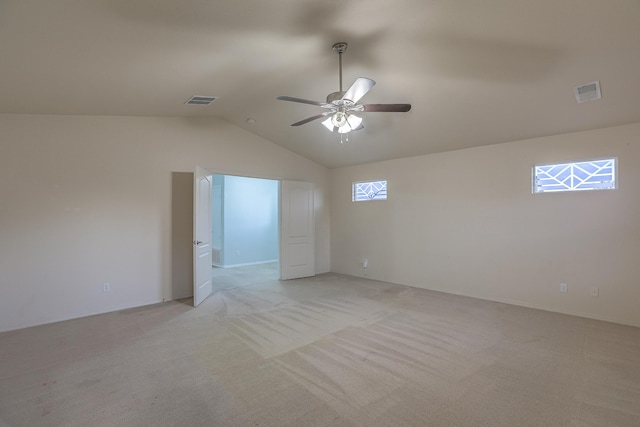 unfurnished room with ceiling fan, lofted ceiling, and light carpet