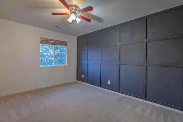 carpeted spare room with ceiling fan