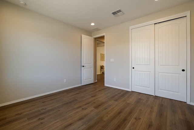 unfurnished bedroom with recessed lighting, a closet, visible vents, dark wood-type flooring, and baseboards