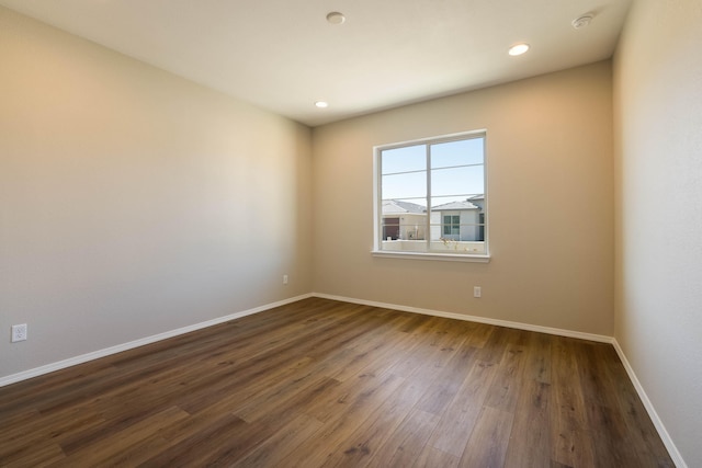 unfurnished room featuring baseboards, dark wood finished floors, and recessed lighting