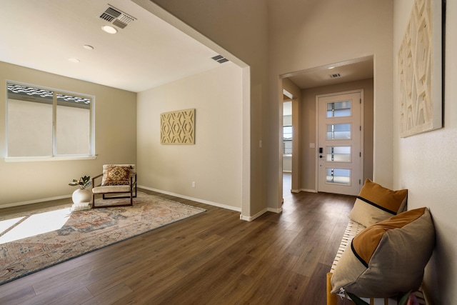 interior space with baseboards, visible vents, and dark wood finished floors