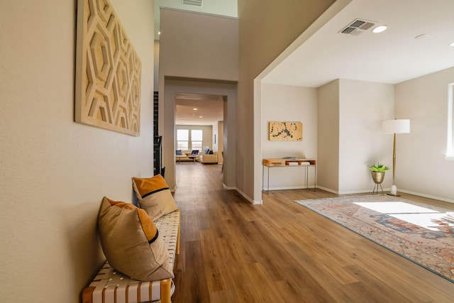 hall with recessed lighting, visible vents, baseboards, and wood finished floors