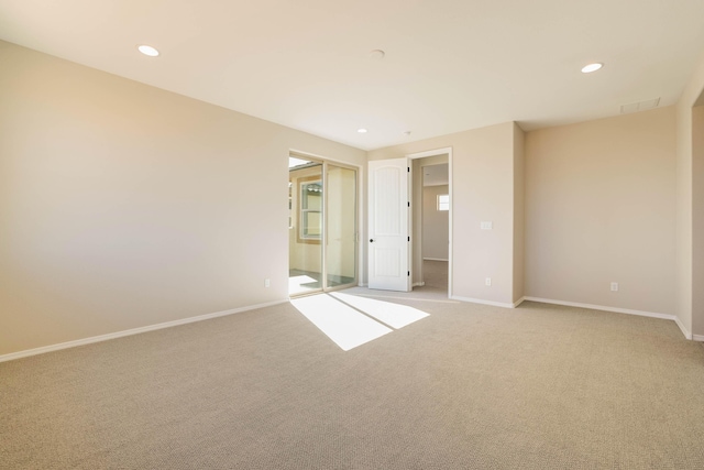 interior space featuring baseboards, recessed lighting, visible vents, and light colored carpet