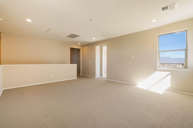 empty room with baseboards, visible vents, light colored carpet, and recessed lighting