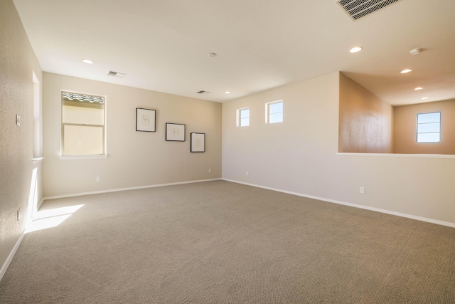 unfurnished room featuring carpet, visible vents, and baseboards