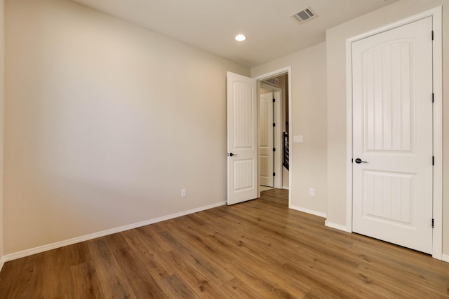 unfurnished bedroom featuring recessed lighting, visible vents, baseboards, and wood finished floors