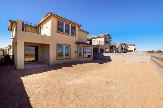 back of house with a patio area, a fenced backyard, a residential view, and stucco siding