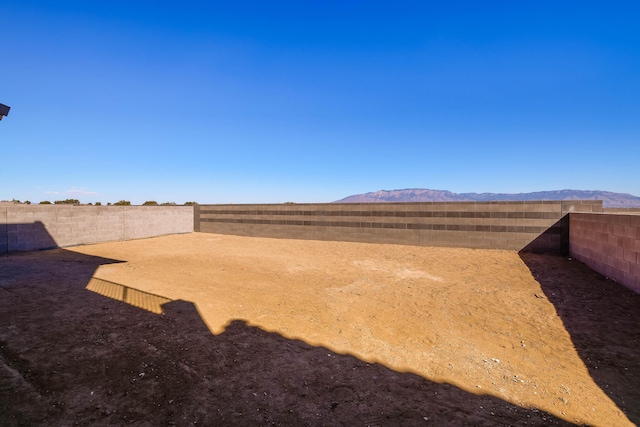 view of yard featuring a fenced backyard and a mountain view