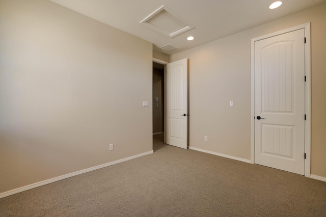 unfurnished bedroom featuring carpet floors, recessed lighting, attic access, and baseboards