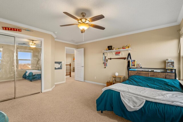 bedroom with crown molding, ceiling fan, a closet, and carpet