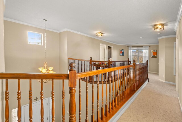 hallway featuring ornamental molding and an inviting chandelier