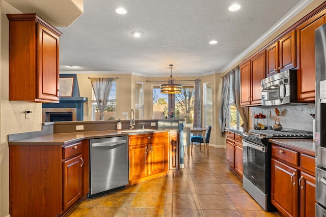 kitchen featuring appliances with stainless steel finishes, sink, decorative backsplash, hanging light fixtures, and ornamental molding