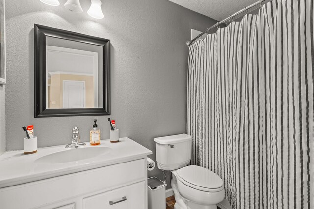 bathroom with vanity, a textured ceiling, and toilet