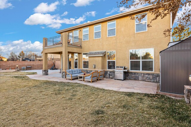 rear view of property with a yard, an outdoor hangout area, a balcony, and a patio area