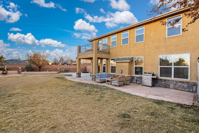 back of property with a patio, a balcony, an outdoor hangout area, and a lawn