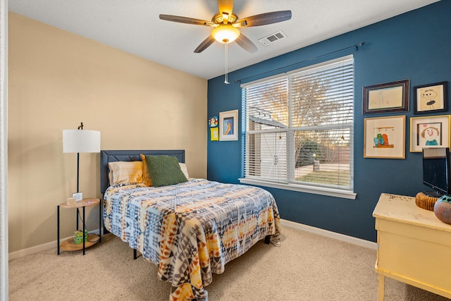 carpeted bedroom featuring ceiling fan and multiple windows