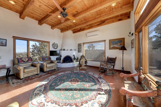 living room with a large fireplace, hardwood / wood-style flooring, beamed ceiling, and a healthy amount of sunlight