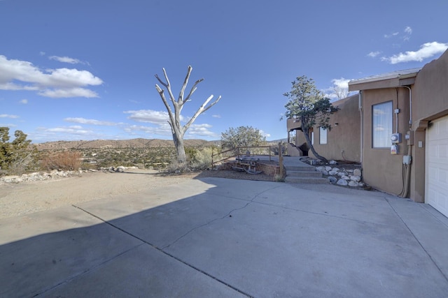 view of patio / terrace with a garage and a mountain view