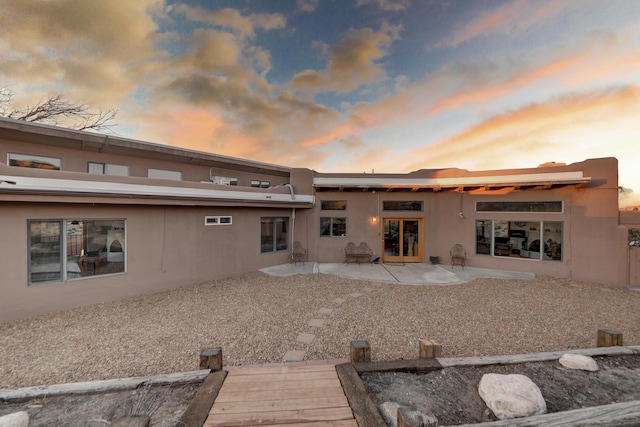 back house at dusk with a patio