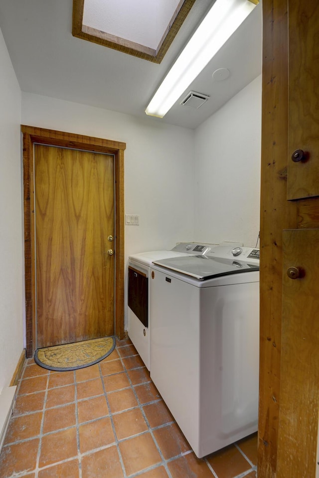 laundry room featuring washer and clothes dryer and light tile patterned flooring