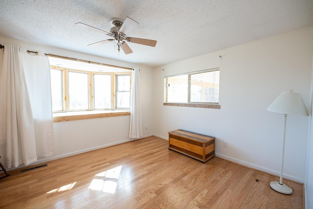 809 Kingman Ave, Grants, NM 87020 - unfurnished room with a textured ceiling, visible vents, ceiling fan, baseboards, and light wood finished floors