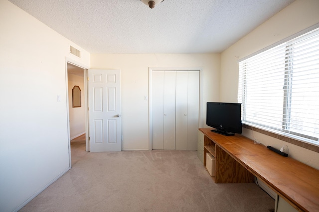 809 Kingman Ave, Grants, NM 87020 - bedroom with a closet, visible vents, light carpet, and a textured ceiling