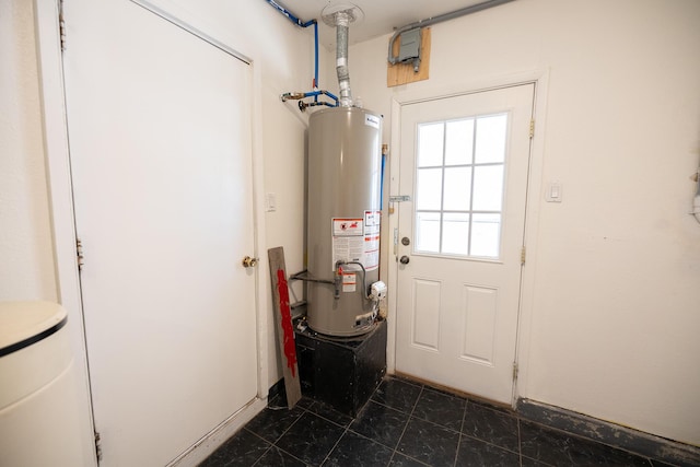 809 Kingman Ave, Grants, NM 87020 - doorway to outside featuring gas water heater and dark tile patterned floors