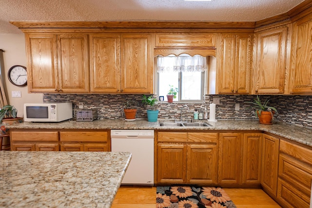 809 Kingman Ave, Grants, NM 87020 - kitchen featuring white appliances, decorative backsplash, a sink, light wood-type flooring, and a textured ceiling