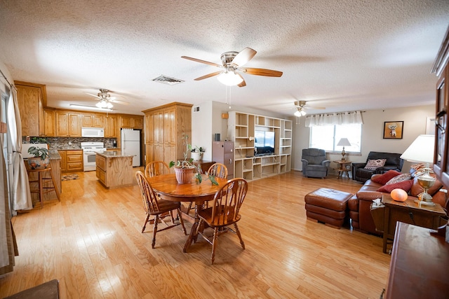 809 Kingman Ave, Grants, NM 87020 - dining room with visible vents, ceiling fan, a textured ceiling, and light wood-style flooring