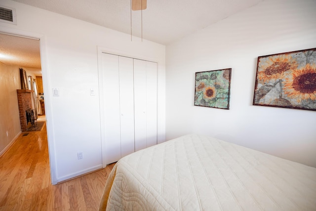 809 Kingman Ave, Grants, NM 87020 - bedroom with visible vents, light wood-style floors, a closet, baseboards, and a ceiling fan