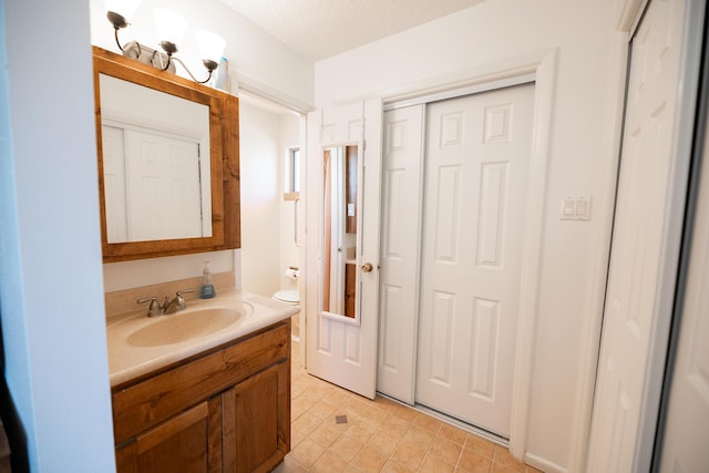 809 Kingman Ave, Grants, NM 87020 - bathroom with toilet, vanity, and a textured ceiling