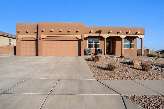 pueblo revival-style home with a garage