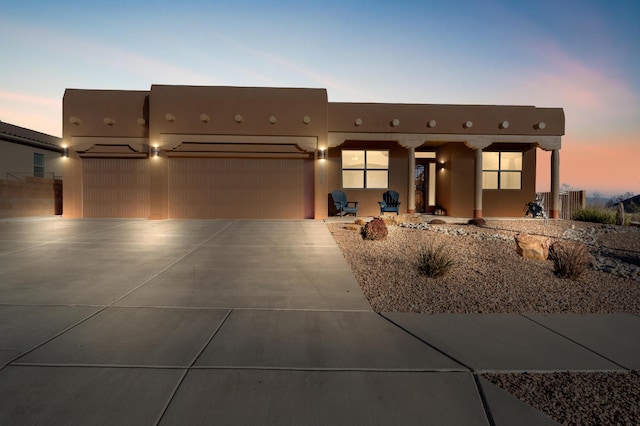 pueblo revival-style home with a garage