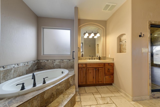 bathroom with tiled tub and vanity