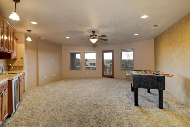 game room with sink, light colored carpet, beverage cooler, and ceiling fan