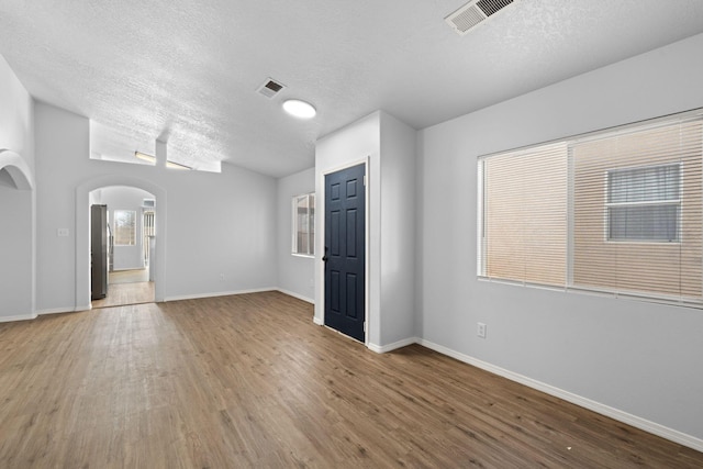 spare room featuring wood-type flooring and a textured ceiling