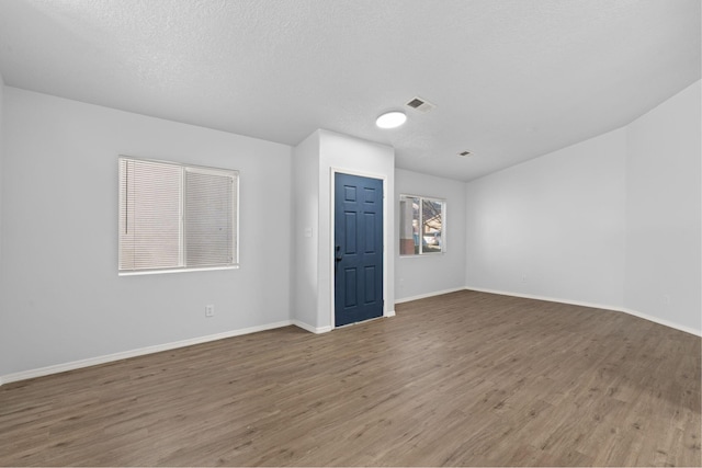 spare room with hardwood / wood-style flooring and a textured ceiling