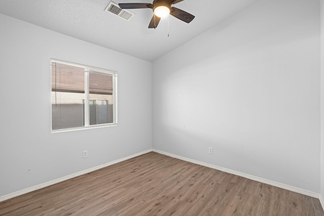 spare room featuring hardwood / wood-style floors, vaulted ceiling, and ceiling fan