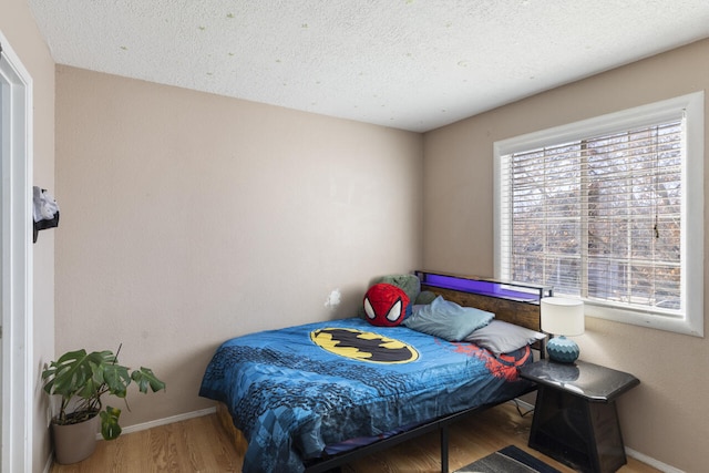 bedroom with hardwood / wood-style floors and a textured ceiling