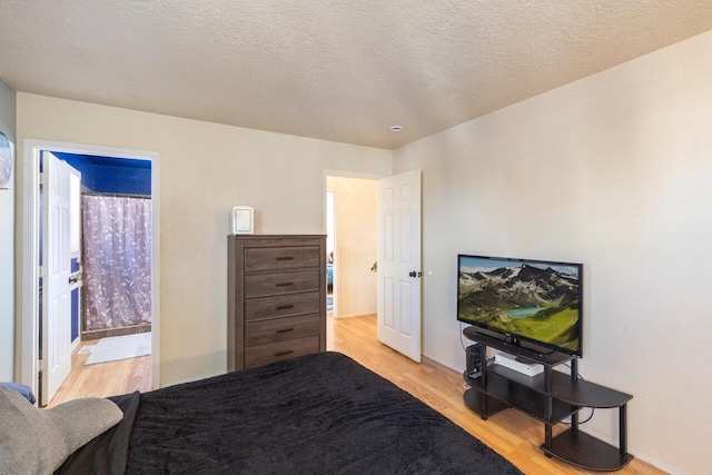 bedroom featuring a textured ceiling and light hardwood / wood-style flooring