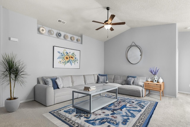 living room featuring ceiling fan, carpet floors, vaulted ceiling, and a textured ceiling