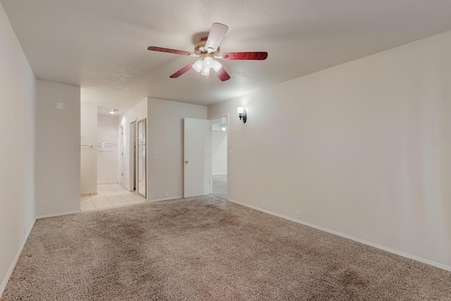 carpeted spare room with ceiling fan