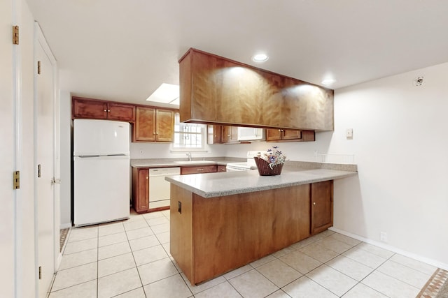 kitchen featuring white appliances, kitchen peninsula, sink, and light tile patterned floors